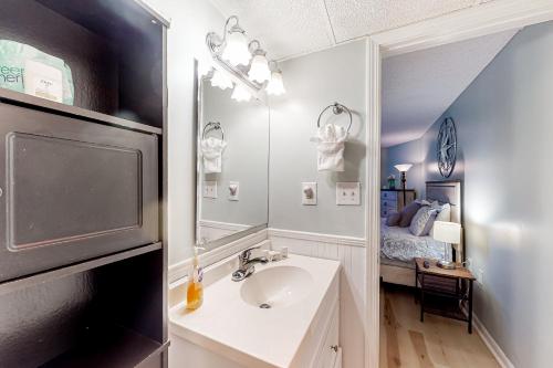 baño con lavabo, espejo y cama en Royal Garden Resort #1514, en Myrtle Beach