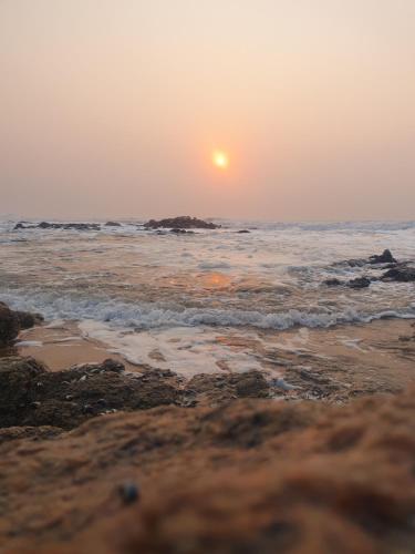 a sunset on the beach with the ocean at Seagulls Beach House in Port Shepstone