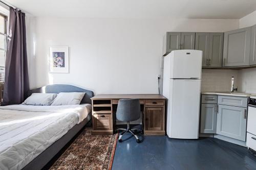 een slaapkamer met een bed, een bureau en een koelkast bij Apartment 1407: East Village in New York