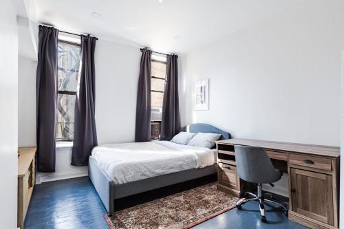 een slaapkamer met een bed, een bureau en een stoel bij Apartment 1407: East Village in New York