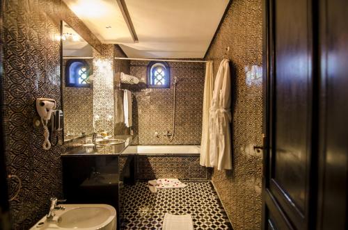 W łazience znajduje się umywalka, toaleta i lustro. w obiekcie Palais Ommeyad Suites & Spa w Fezie