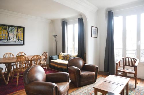 un soggiorno con tavolo e sedie in pelle di Bright and spacious love cocoon in Paris 16th a Parigi