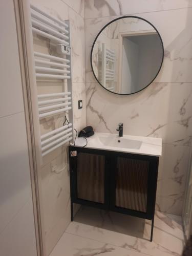 La salle de bains est pourvue d'un lavabo et d'un miroir. dans l'établissement Le refuge du bonheur, à Trévoux