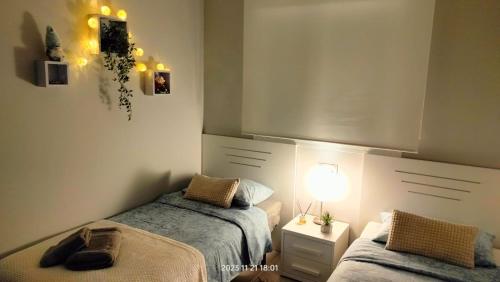 a bedroom with two beds and a lamp in it at Nova Beach Apartment 41 in Gran Alacant