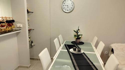 mesa de comedor con sillas y reloj en la pared en Nova Beach Apartment 41, en Gran Alacant