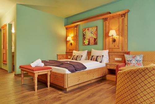 a bedroom with a large bed and a chair at carpe solem KAPOOM incl Zell am See-Kaprun Summer Card in Kaprun