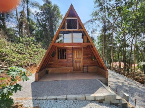una casa pequeña con techo de paja en Chalé - Romântico na Natureza, en Itapecerica da Serra