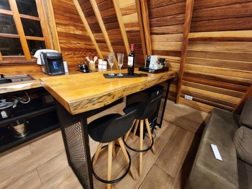 una cocina con una mesa de madera y una botella de vino en Chalé - Romântico na Natureza, en Itapecerica da Serra