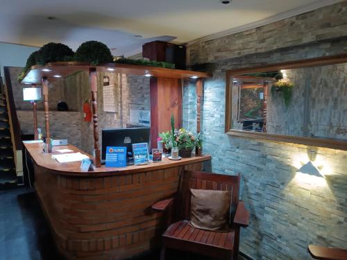 a bar in a restaurant with a wooden counter at Hotel La Gran Manzana in Puerto Iguazú
