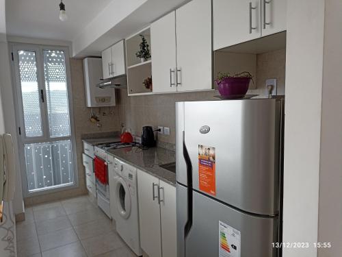 a kitchen with a refrigerator and white cabinets at Los Juncos Jujuy in San Salvador de Jujuy