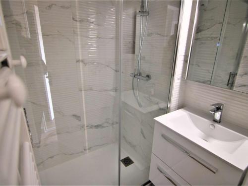 ein weißes Bad mit einer Dusche und einem Waschbecken in der Unterkunft Appartement Les Saisies, 4 pièces, 8 personnes - FR-1-594-323 in Hauteluce