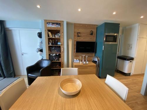 une cuisine et une salle à manger avec une table et des chaises en bois dans l'établissement Appartement cosy proche pistes et remontées avec balcon, accès wifi - FR-1-459-224, à La Clusaz