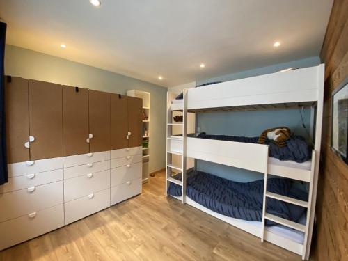- une chambre avec 2 lits superposés et des armoires dans l'établissement Appartement cosy proche pistes et remontées avec balcon, accès wifi - FR-1-459-224, à La Clusaz