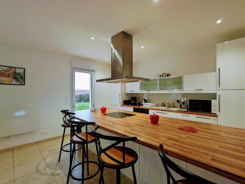 - une cuisine avec un comptoir en bois et des tabourets dans l'établissement Maison spacieuse à la campagne avec jardin, 4 chambres, proche château de Valençay et Zoo de Beauval - FR-1-591-562, à Vicq-sur-Nahon