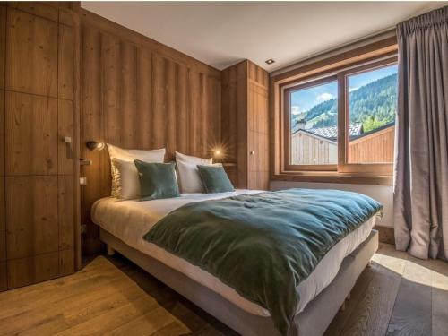 a bedroom with a large bed with a large window at Maison Courchevel, 5 pièces, 8 personnes - FR-1-772-4 in Courchevel
