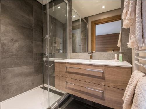 W łazience znajduje się szklana kabina prysznicowa i umywalka. w obiekcie Maison Courchevel, 5 pièces, 8 personnes - FR-1-772-4 w Courchevel