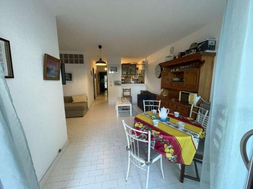 une pièce avec une table et des chaises dans une cuisine dans l'établissement Appartement RDC à Port Camargue - 6 Couchages, Accès Direct Plage, Parking, Jardin - FR-1-250-263, au Grau-du-Roi