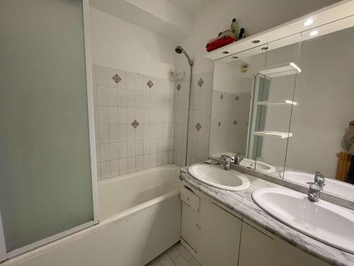 une salle de bain avec deux lavabos, un miroir et une baignoire dans l'établissement Appartement RDC à Port Camargue - 6 Couchages, Accès Direct Plage, Parking, Jardin - FR-1-250-263, au Grau-du-Roi