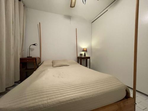 une chambre avec un grand lit dans une pièce dans l'établissement Appartement RDC à Port Camargue - 6 Couchages, Accès Direct Plage, Parking, Jardin - FR-1-250-263, au Grau-du-Roi