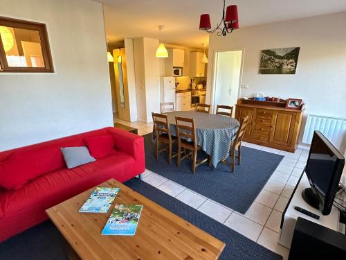 un salon avec un canapé rouge et une table dans l'établissement Appartement 6 pers. avec balcon et garage au cœur de Villard-de-Lans - FR-1-515-198, à Villard-de-Lans