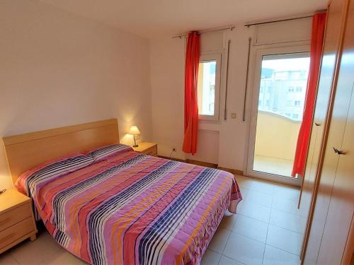 a bedroom with a bed and a window with red curtains at Apartamento Llançà, 2 dormitorios, 5 personas - ES-170-34 in Llança