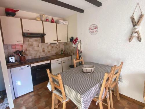 une cuisine avec une table et des chaises dans une cuisine dans l'établissement Appartement 3 pièces avec balcon, proche commodités, ascenseur - FR-1-515-203, à Villard-de-Lans