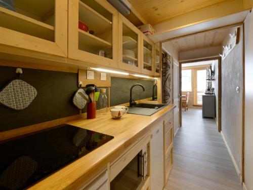 - une cuisine dans une petite maison avec des placards en bois dans l'établissement Superbe studio cabine rénové accès direct aux pistes - FR-1-181-2734, à Aime La Plagne