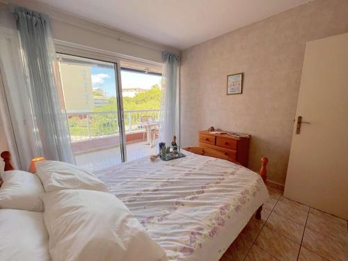une chambre avec un lit et une grande fenêtre dans l'établissement Appartement 2 pièces proche plage avec garage, Fréjus - FR-1-226A-167, à Fréjus