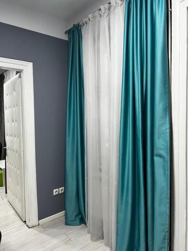 Cette chambre dispose de rideaux bleus et blancs et d'un miroir. dans l'établissement Sandra City Center Apartment, à Belgrade