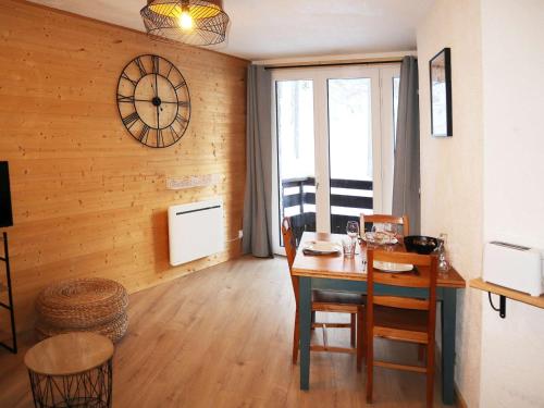 une salle à manger avec une table et une horloge au mur dans l'établissement Studio Confort 6 Pers, Balcon Sud, Accès Pistes & Navette - Les Orres 1650 - FR-1-322-538, aux Orres