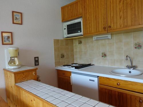 une cuisine avec un évier et un micro-ondes dans l'établissement Studio cabine ski et rando, 4 pers, pied des pistes, Arêches-Beaufort - FR-1-342-313, à Beaufort