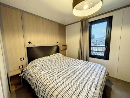 une chambre avec un lit et une fenêtre dans l'établissement Chalet standing avec piscine chauffée, 4 couchages, proche plage et commerces, WIFI inclus - FR-1-361-527, à Jullouville