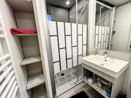 une salle de bain avec douche et lavabo dans l'établissement Chalet standing avec piscine chauffée, 4 couchages, proche plage et commerces, WIFI inclus - FR-1-361-527, à Jullouville