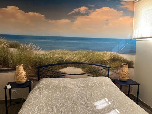 - une chambre avec un lit et une peinture sur la plage dans l'établissement Appartement Vaux-sur-Mer, 4 pièces, 6 personnes - FR-1-539-57, à Vaux-sur-Mer