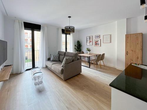 ein Wohnzimmer mit einem Sofa und einem Tisch in der Unterkunft Picú Home - Nueva apertura in Málaga