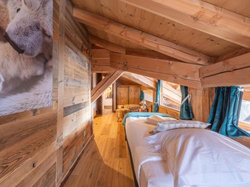 Ce lit se trouve dans un dortoir doté de murs en bois. dans l'établissement Superbe duplex au calme proche des pistes avec parking et wifi - FR-1-645-54, à Huez