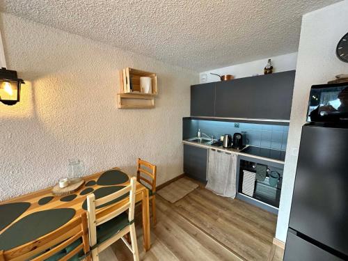 una pequeña cocina con mesa y nevera en Studio Corrençon-en-Vercors, 1 pièce, 4 personnes - FR-1-515-204, en Corrençon-en-Vercors