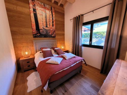 une chambre avec un lit et une grande fenêtre dans l'établissement Séjour cocooning aux Gets: 3 chambres, balcon, parking, Wi-Fi - FR-1-598-156, aux Gets