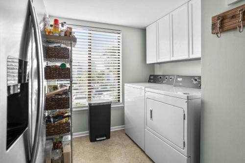 a kitchen with white cabinets and a refrigerator at Harbor Island E204 in Oceanmarsh Subdivision
