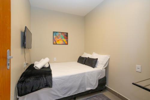 a bedroom with a bed with white sheets and pillows at Botanical House, bairro Jardim Botânico 3 de Bsb in Brasilia