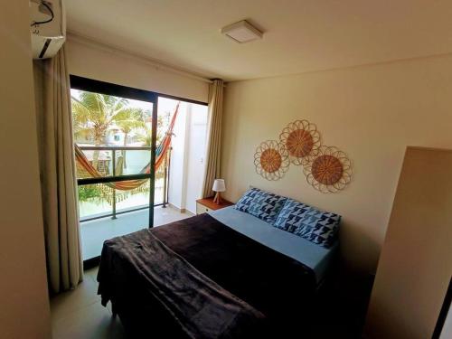 a bedroom with a bed and a large window at Flat mais Charmoso da região de Porto de Galinhas in Porto De Galinhas