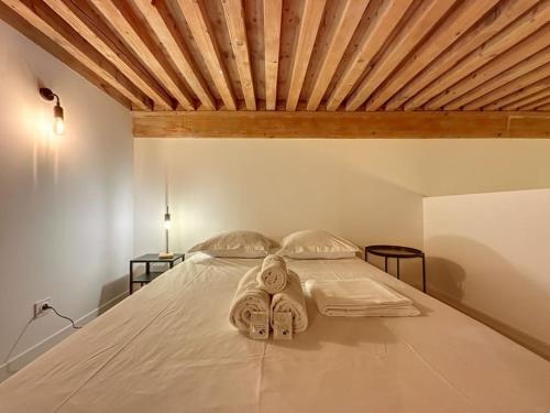 um quarto com uma cama e um tecto em madeira em Cosy appt, Croix Rousse Duviard 1 em Lyon