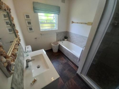 ein Badezimmer mit einer Badewanne und einem Waschbecken in der Unterkunft Seagulls Beach House in Port Shepstone