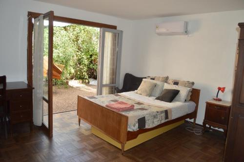een slaapkamer met een bed en een glazen schuifdeur bij 3B Habitación SUR con baño privado y AC in Salto