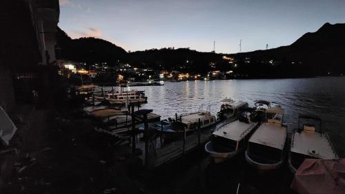 a group of boats docked in a lake at night at San Pedro Suite in San Pedro La Laguna