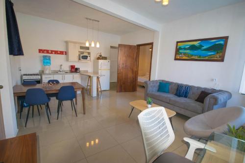 a living room and kitchen with a couch and a table at San Pedro Suite in San Pedro La Laguna