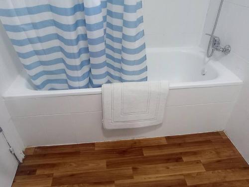 ein Badezimmer mit einer weißen Badewanne und einem Duschvorhang in der Unterkunft Casa Sierra norte de Madrid in Navalquejigo