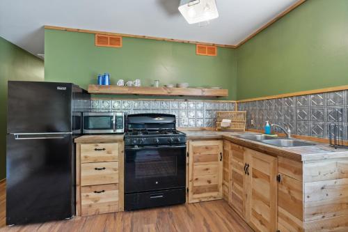 a kitchen with a black refrigerator and a sink at HTR Durango in Durango