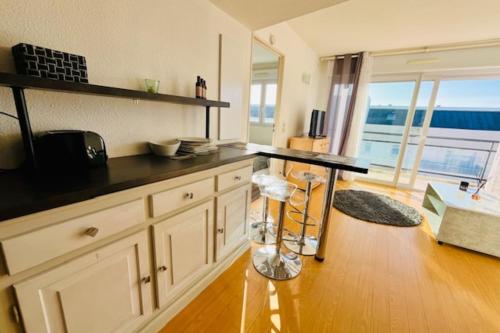 uma cozinha com um balcão e uma mesa em Charming love nest with balcony em La Rochelle