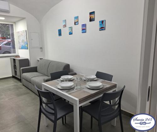 a living room with a table and chairs and a couch at Savoia 215 - Azzurra Guest House - Napoli in Naples